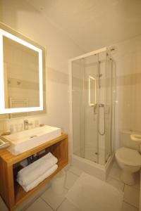 La salle de bains est pourvue d'un lavabo, d'une douche et de toilettes. dans l'établissement ULVF les Ramondies, à Saint-Lary-Soulan