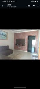 ein Wohnzimmer mit einem Sofa und einem TV an der Wand in der Unterkunft Recanto Cote Gil in Olímpia