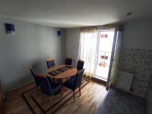 een eetkamer met een tafel en stoelen en een raam bij Apartment Jasmina Sarajevo in Sarajevo