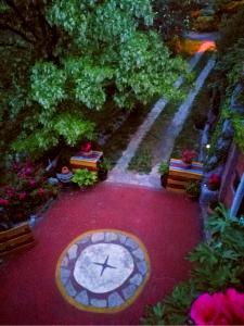 a clock on a red carpet with trees and flowers at Krasberry in Komen