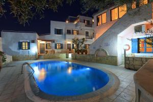 a swimming pool in front of a building at night at Stelva Villas in Hersonissos