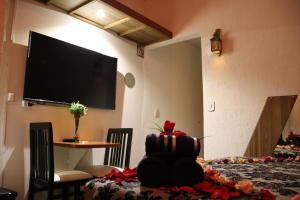 um quarto com uma mesa e uma televisão na parede em Arraialferias Suites em Arraial do Cabo