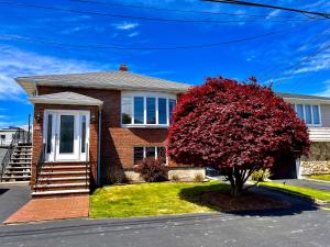 a house with a red tree in front of it at Daybed with trundle - access to home library & bar in Revere