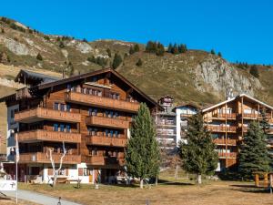 a large wooden building with a mountain in the background at Apartment Südlenz 41 by Interhome in Riederalp