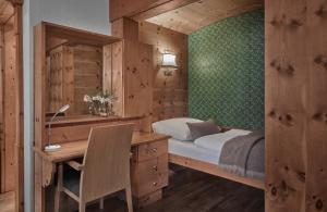 a bedroom with a bed and a desk and a desk at Hotel Goldener Greif in Kitzbühel +24 photos