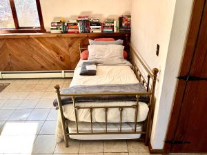 ein kleines Bett in einer Ecke eines Zimmers in der Unterkunft Daybed with trundle - access to home library & bar in Revere