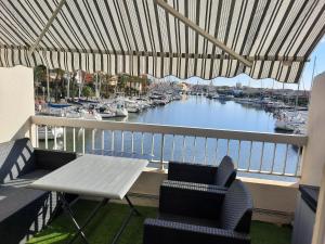 a balcony with a table and chairs and a marina at Duplex sur Marinas Cap d'Agde in Cap d'Agde