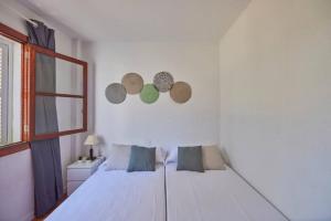 a white bedroom with a bed and a window at Nura Houses Apartment Magaluf 3 in Magaluf