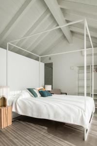 シルヴェスにあるCasa Aradeの白いベッドルーム(青い枕の白いベッド付)