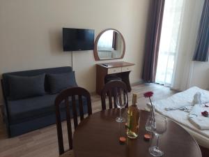 a living room with a table and a couch at Хотел Флора private studio All seasons in Borovets