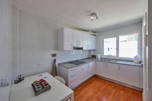 a white kitchen with white cabinets and a window at Nura Houses Duplex Magaluf 1 in Magaluf