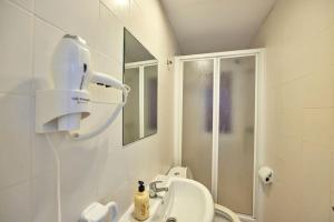 ein weißes Bad mit einer Dusche und einem Waschbecken in der Unterkunft Nura Houses Apatment Magaluf 4 in Magaluf