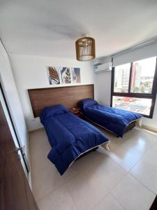 two beds in a room with blue pillows at Marqués de Tojo Urbano in San Salvador de Jujuy