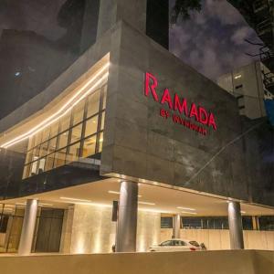 a building with a red sign on the side of it at Ramada by Wyndham Brasilia Alvorada in Brasília