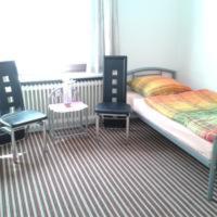 1 dormitorio con 1 cama, 2 sillas y mesa en Gästehaus Am See -Monteurzimmervermietung-, en Vienenburg