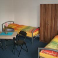 1 dormitorio con 2 camas, escritorio y mesa en Gästehaus Am See -Monteurzimmervermietung-, en Vienenburg