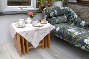 a table with a tea set on it next to a couch at Mellowvean in St. Agnes +8 photos