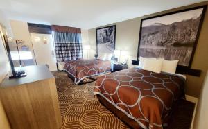 una camera d'albergo con due letti e una scrivania di Super 8 by Wyndham Marion NC a Marion Altre 24 foto