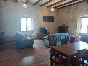 uma sala de estar com uma mesa e cadeiras e uma televisão em Casa Els Arcs em Castellfort