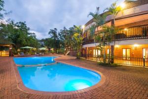 a swimming pool in front of a building at Greenway Woods Accommodation in White River