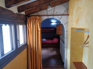 a hallway with a window and a bed in a room at Casa Els Arcs in Castellfort