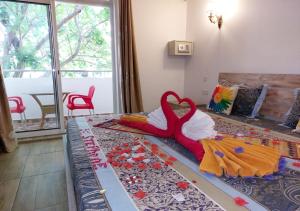 a red and white teddy bear sitting on top of a bed at Easy Stay Residence in Trou aux Biches