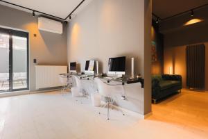 a room with white chairs and a table with two monitors at Eco Smart Apartments Premium City in Nürnberg