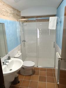y baño con ducha, aseo y lavamanos. en Casa Els Arcs, en Castellfort