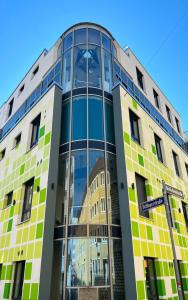 un edificio con azulejos verdes y amarillos. en Eco Smart Apartments Premium City en Núremberg