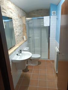 uma casa de banho com um WC, um lavatório e um chuveiro em Casa Els Arcs em Castellfort