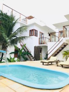 a swimming pool in front of a house at Villa Mar Residence in Jericoacoara