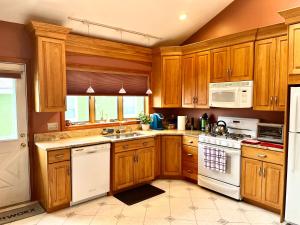 a kitchen with wooden cabinets and white appliances at Inviting room with workstation in Revere