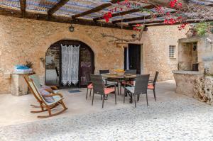 een patio met een tafel en stoelen in een gebouw bij YourHouse Son Costa Villa in Sineu