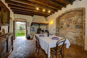 Casale Lucrezia by Garda FeWo في سالو: غرفة طعام مع طاولة وجدار من الطوب