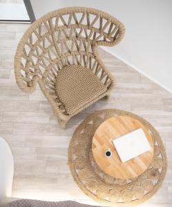 a rattan chair and a table in a room at Majestique of Naxos boutique hotel in Naxos Chora