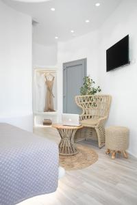 a bedroom with a bed and a table and a chair at Majestique of Naxos boutique hotel in Naxos Chora