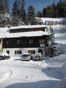 two cars parked in front of a building in the snow at Haus Elisabeth Apartments in Obertauern