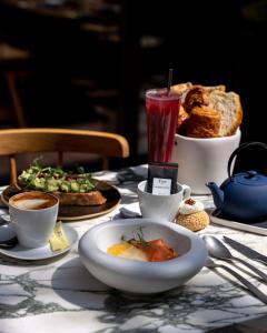 a table with a plate of food and a drink at VILLA M in Paris