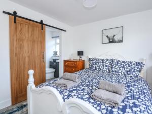 a bedroom with a blue and white bed with two pillows at Waterbeach in Mablethorpe