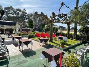 un grupo de mesas y sillas en un patio en Hostal Restaurante Luz de Luna, en Villanueva de Arosa