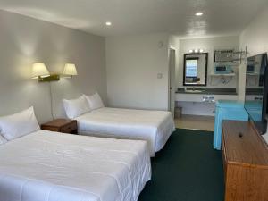 a hotel room with two beds and a television at Poolside Double Rooms in Lake City