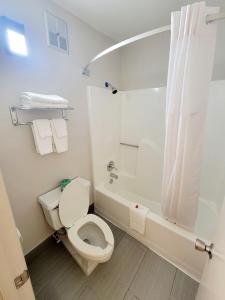 e bagno bianco con servizi igienici e vasca. di Super 8 by Wyndham Marion NC a Marion