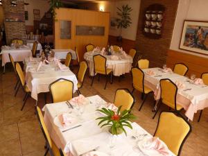 a dining room with white tables and yellow chairs at Hotel Guillermo II in Mazarrón