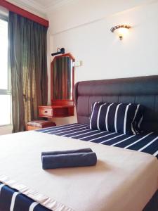 Una habitación de hotel con una cama con una toalla. en Glory Beach Resort PriVate PentHouse en Port Dickson