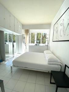 a large white bedroom with a large bed in it at ÉLÉGANT STUDIO DANS BATIMENT HISTORIQUE in Saint-Tropez
