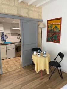 um quarto com uma mesa e cadeiras e uma cozinha em Charmant studio à 2 pas du centre historique em Sommières