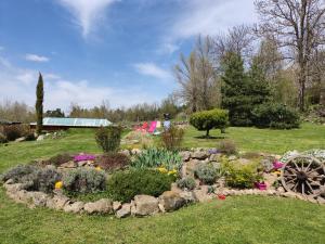 um jardim com flores e pedras num campo em La Chabanade em Saint-Pierre-Eynac