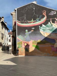 a large mural of a person in a boat on a wall at Apartment ALMA- Vodnjan- smještaj blizina mora sa besplatnim javnim parkingom in Vodnjan +6 photos