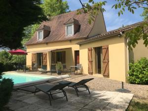 a house with a swimming pool in front of a house at Les Mas du Peintre in Sarlat-la-Canéda