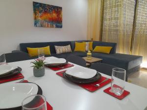 uma sala de estar com um sofá e uma mesa com copos de vinho em AgadirBay em Agadir
